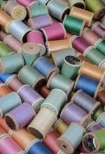 Vibrant close-up of various colored sewing thread spools for crafting and textile projects.